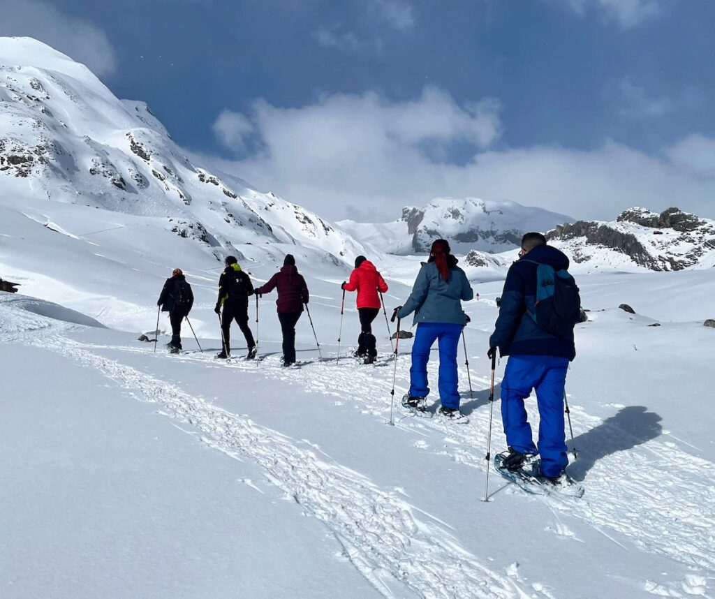 Progresión de grupo iniciando una ruta guiada con raquetas de nieve en el Valle de Tena, Pirineo Aragonés
