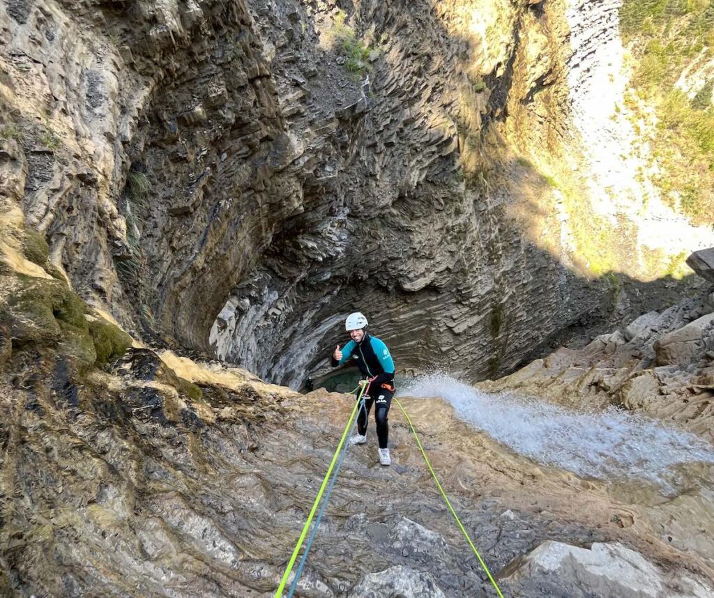 Participante realizando el rápel de 30 metros en la cascada del Barranco de Os Lucas, Orós Bajo.