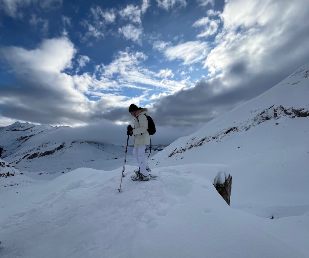 Participante descendiendo durante una excursión circular con raquetas de nieve en el Pirineo Aragonés