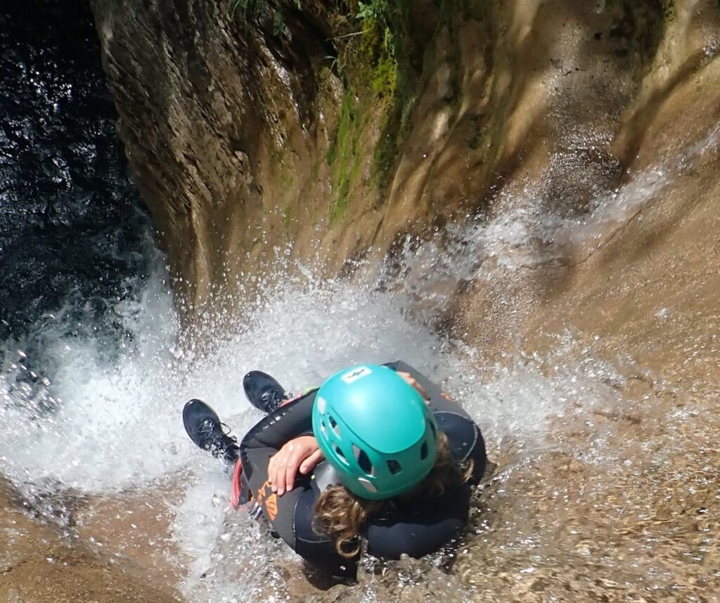 Participante comenzando el barranco del forcos en el tobogan de 11 metros por la cascada