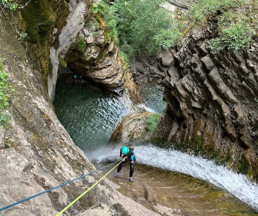 Participante descendiendo el primer rapel de entrada en el barranco del Furco, una maniobra de iniciacion segura guiada por Green Pyrenees en Broto.